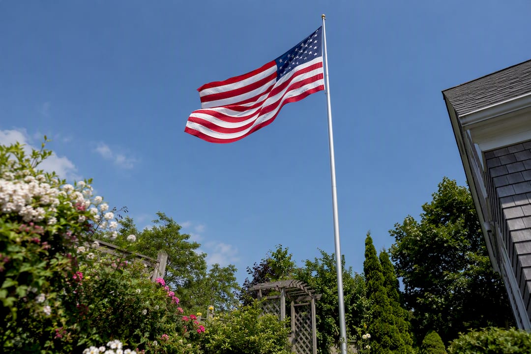 Different sized flags on varying height poles outside