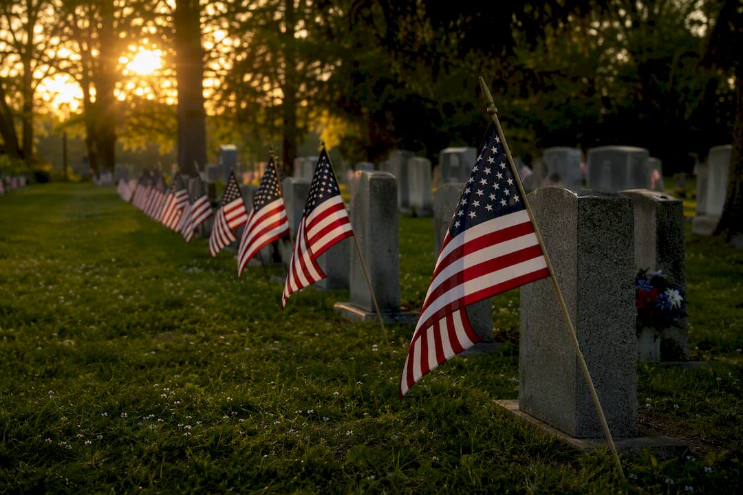 Flags placed by graves at cemetery