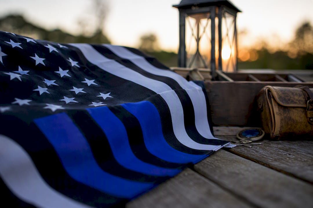 Folded thin blue line flag on wooden table