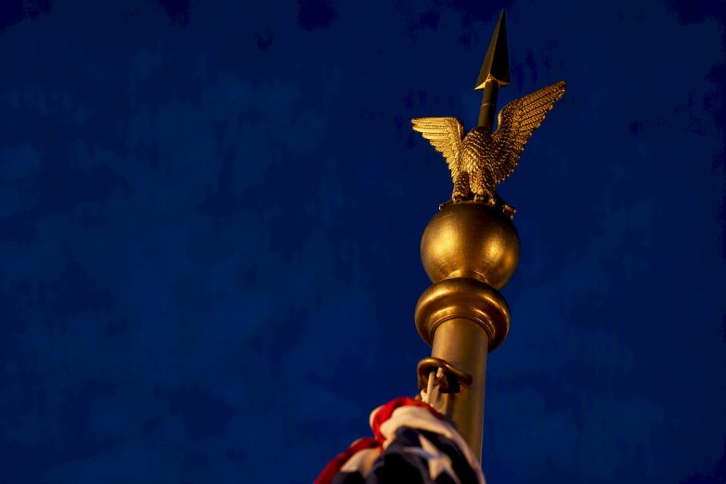 Flagpole finials silhouetted against twilight sky