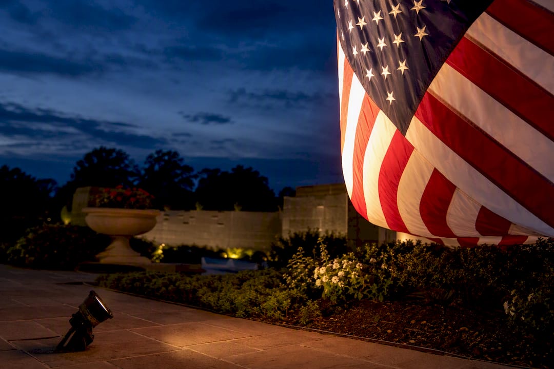 Spotlight illuminating a flag at dusk