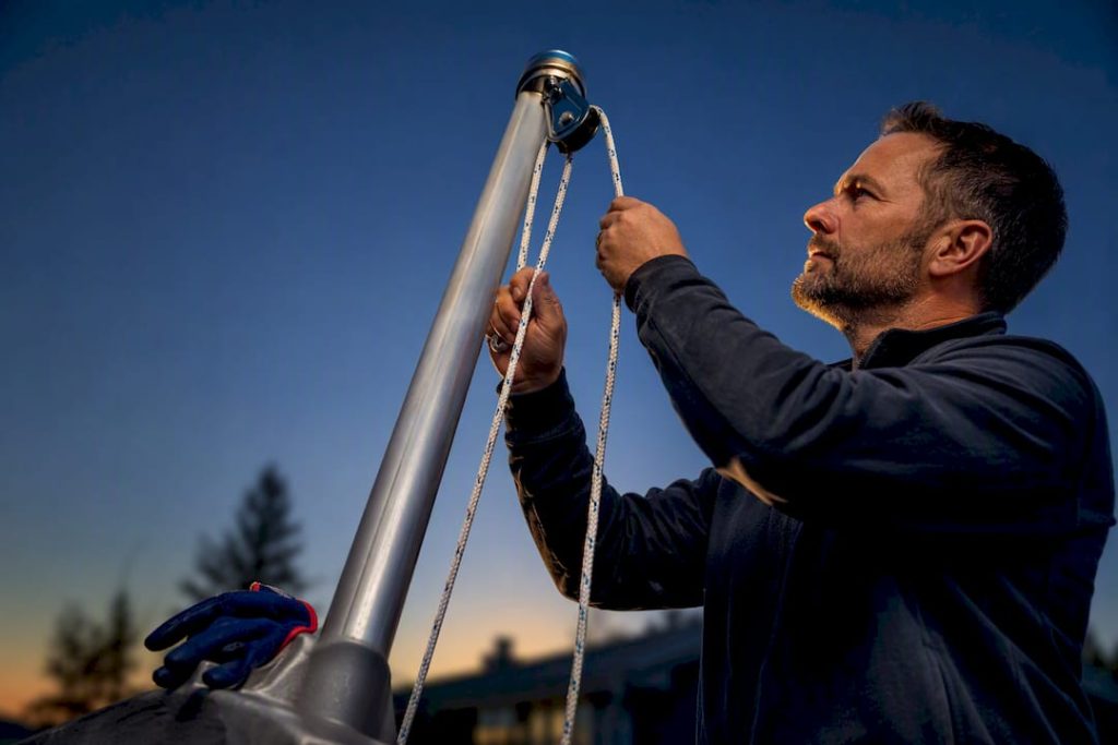 Homeowner threading rope through flagpole pulley