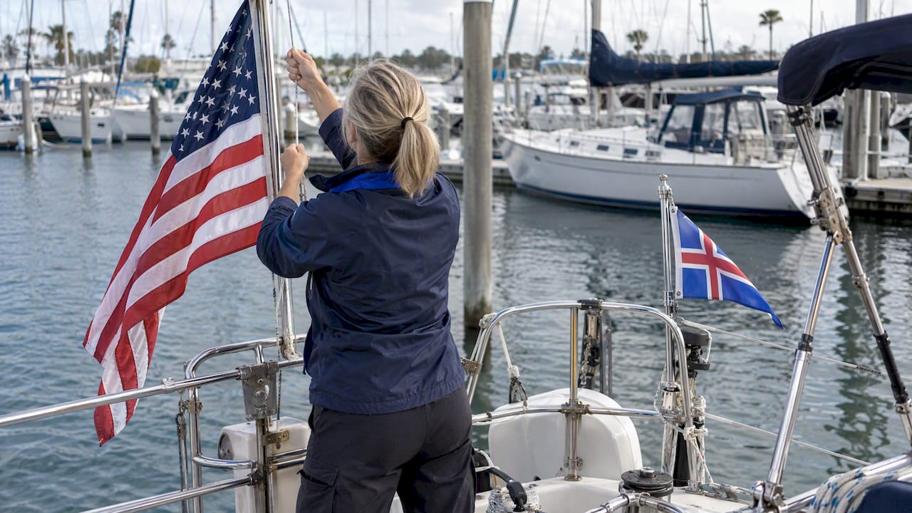 Cruiser raising ensign and courtesy flag